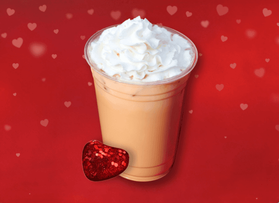 Iced latte with whipped cream and a red background. Heart next to the Latte.